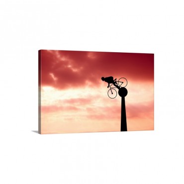 Silhouette Of Cyclist Sculpture With Moody Red Sunset And Cloudy Sky Vehind Wall Art - Canvas - Gallery Wrap